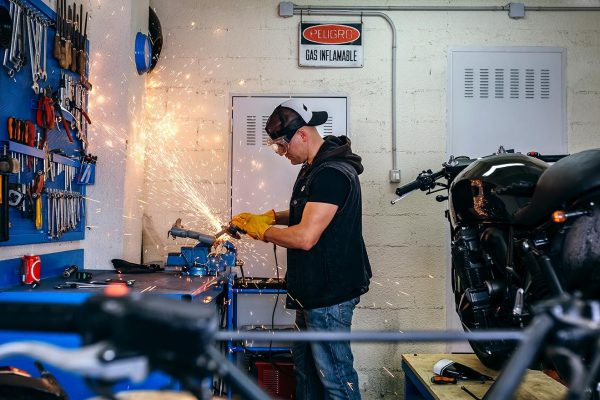 motorcycle-mechanic-using-a-grinder-B3JSF5V-resize